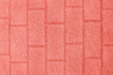 Coral color grass background with a brick wall texture. Color of the year 2019.