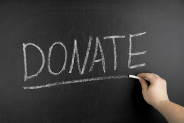 Donate text on black chalkboard, business concept background