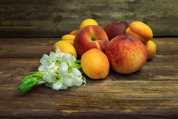Ripe fruits of peaches and apricots close up on a wooden board