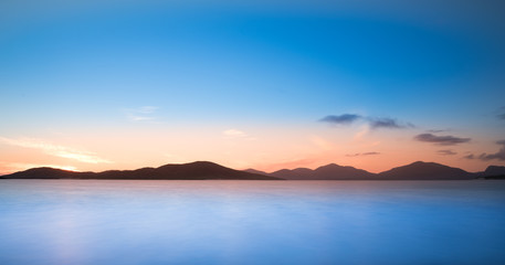 Isle of Harris landscape - sunset sky over mountains, beautiful endless sandy beach and turquoise ocean