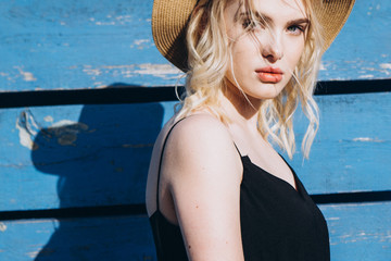 Stylish pretty girl with puffy lips and a penetrating gaze,  in dark dress poses for a photo on a...