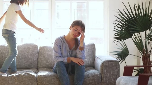 Tired upset single mother stressed about active naughty child daughter