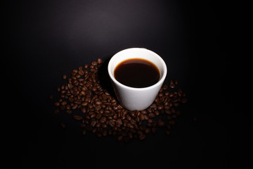 Cup of coffee and coffee beans with background lighting