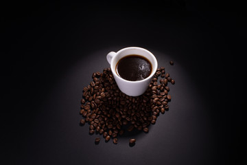 A full cup of coffee and coffee beans are lit around the top.
