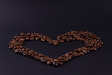 Big heart of coffee beans on a dark surface