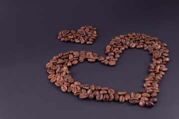 Big and small hearts from coffee in the lower right corner on a dark background.