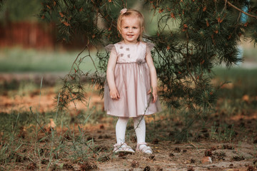 Portrait girl outdoors. cute girl walking in the woods. Amazing little girl in a dress funny posing...