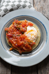 Mexican food: Fried egg rancheros with sauce and corn tortilla