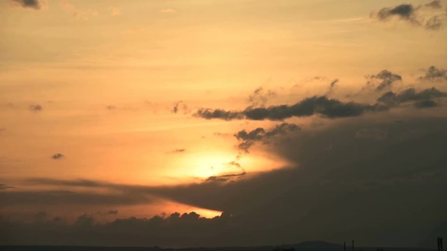 Superzoom plan timelapse sunset through sunset clouds in orange tones. Low key