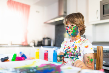 Cheerful child painting with colorful paint