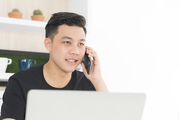Young asian businessman in casual suit use computer notebook and do conversation with customers by phone, Freelance business, Copy space top right
