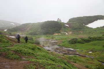 Tourists go along the creek in the Kamchatka region
