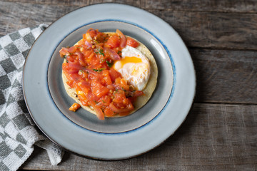 Mexican food: Fried egg rancheros with sauce and corn tortilla