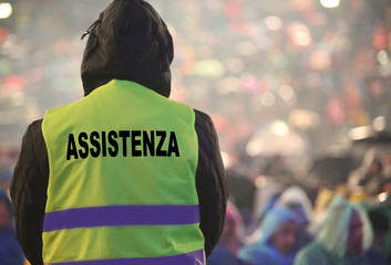boy with high visibility jacket and the text that means ASSISTAN
