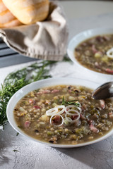 Rustic bean and farro soup with pancetta, onion, rosemary and celery. Italian food.