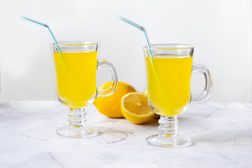 Lemonade refreshing drink in a glass beaker on a light background
