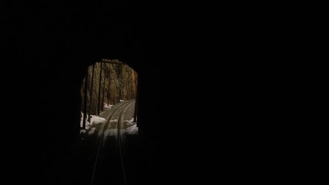 Train passing through tunnel in snowy mountain pass