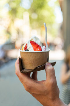 Hand Holding Paper Cup With Ice Cream On Blurred Backgruond