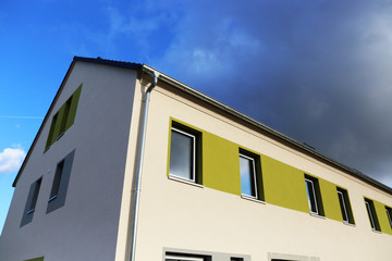 Modern apartment building with blue sky and clouds