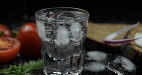Alcohol drink vodka in shot glass. Surface with snacks
