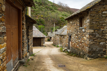 Casas tradicionales en piedra con tejados de pizarra en paisaje montañoso. Provincia de Leon en España