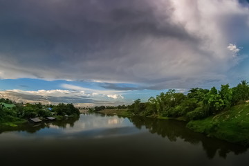 river view evening of Mae Klong river with soft rain and cloudy sky background, Ban Pong District, Ratchaburi, Thailand.