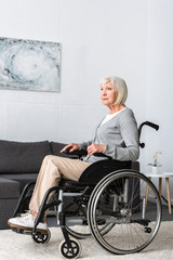Fototapeta na wymiar disabled senior woman sitting in wheelchair and looking away