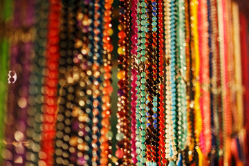 Colorful jewelry beads on the Indian night market, hang on the counter of Goa, India