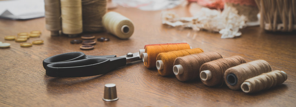 Sewing concept. Scissors, threads and buttons.