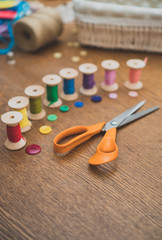 Sewing concept. Scissors and colorful thread spools.