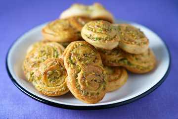 Pistachio roll buns served in a white plate with black rim. Violet linen napkin, high resolution