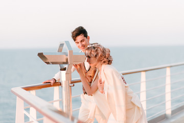 Fototapeta na wymiar Young beautiful couple on the deck of a cruise liner in the sea