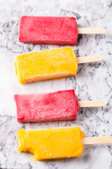 Assortment of fruit popsicles on a gray background