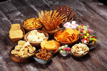 Obraz na płótnie Canvas Salty snacks. Pretzels, chips, crackers in wooden bowls on table