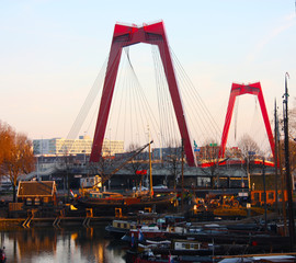Willemsbrug, the red bridge in Rotterdam seen at sunset time over the harbor
