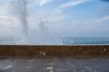 Naklejka na ściany i meble Waves breaking on the seafront of Comillas, Cantabria, Spain, Europe