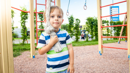 Closeup portrait of adorable smiling happy little boy on children playground at park