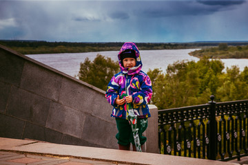 child walks with an umbrella along the promenade
