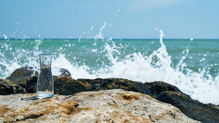 Glass bulb. Sea shore. Waves hit the stones.