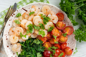 Grilled shrimps and tomatoes with spinach, garlic and parsley.