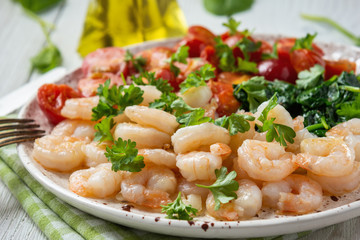 Grilled shrimps and tomatoes with spinach, garlic and parsley.