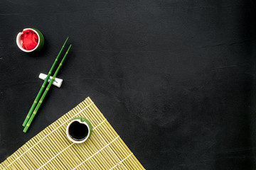 bamboo sticks, soy sauce, ginger for sushi and maki on black background top view mockup © 9dreamstudio