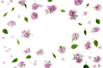 frame with leaves and lilac petals on white background. flat lay, overhead view