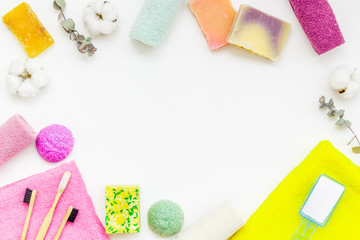 Wash and care products and cotton towels frame on white background top view space for text