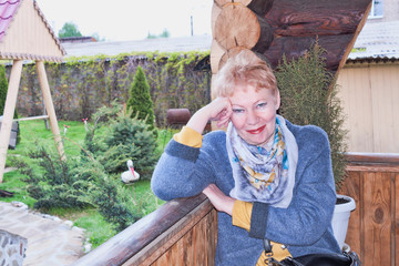 Portrait of a mature woman sitting in a wooden gazebo on a bench