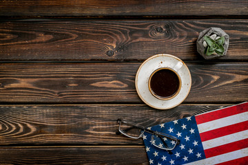 USA national day background with flag and cup of coffee on wooden desk top view copy space