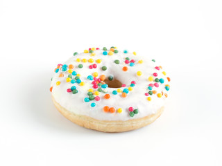 Donut with white glaze and colored sprinkles on a white background.