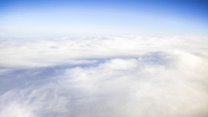 The beautiful cloudscape with clear blue sky. A view from airplane window.