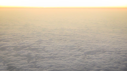Aerial traveling. Flying at dusk or dawn. Fly through orange cloud and sun.