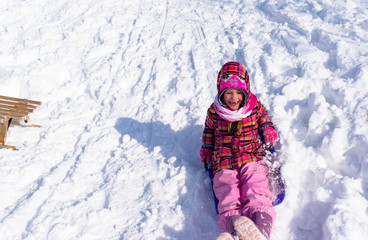 Mädchen rodelt im Schnee